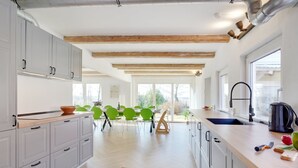 A modern kitchen with white cabinets, a wooden ceiling, and a large window. - "Rouwen" - 1km from the sea by Interhome (Sakskøbing)