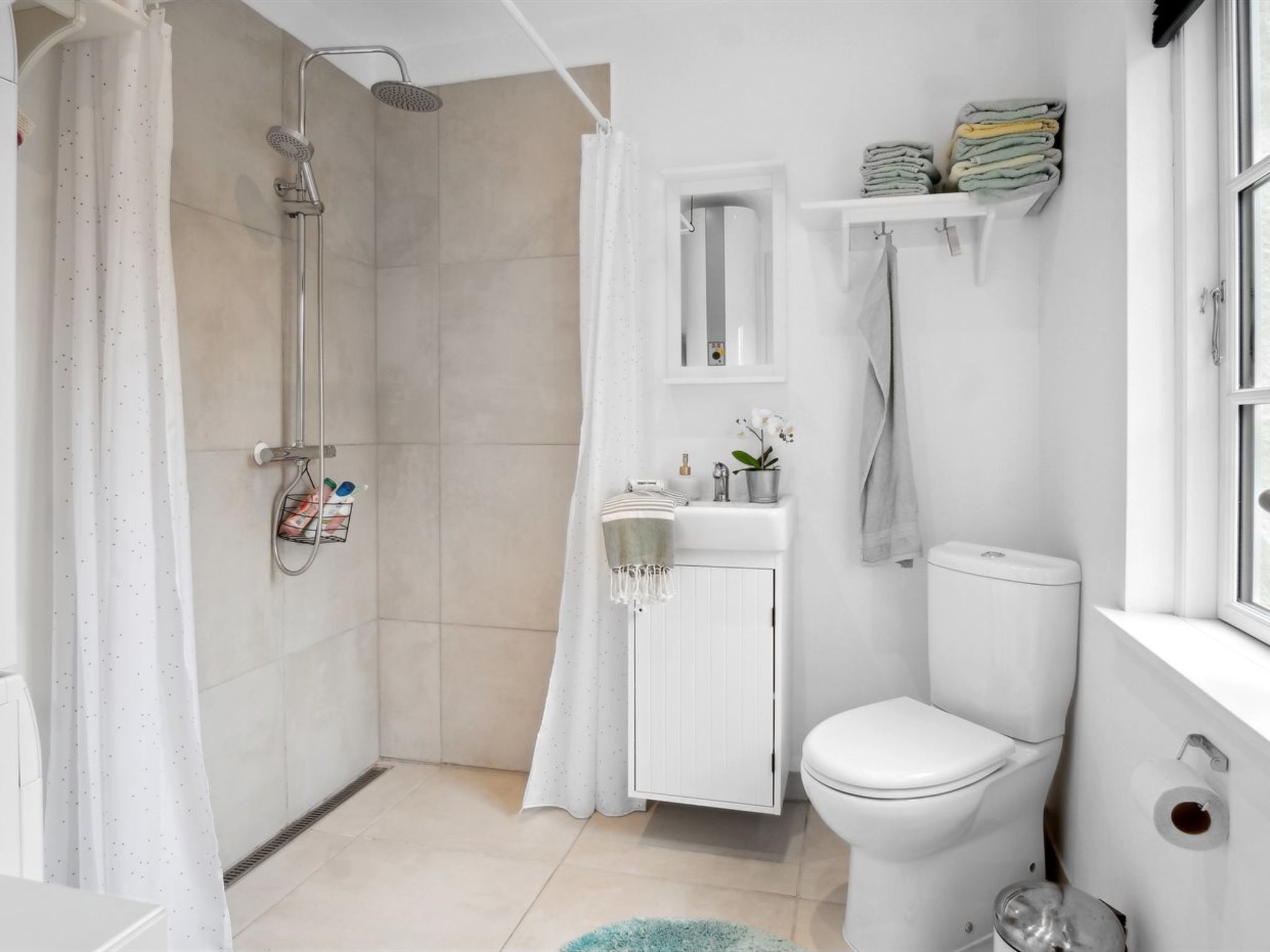 A modern bathroom with a shower, toilet, and sink.