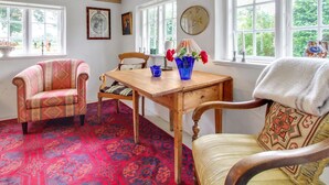 A cozy room with a wooden table, two chairs, a patterned rug, and a window with a view of greenery. - "Saarah" - 25km from the sea by Interhome (Bredebro)