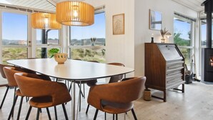 A dining area with a round table, six chairs, and two pendant lights. - "Tiane" - 800m from the sea by Interhome (Fanø)