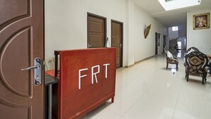 A hallway with a wooden cabinet labeled "FRT," a staircase, and traditional chairs. - OYO 90595 Ferezsa Kost Syariah (Palembang)
