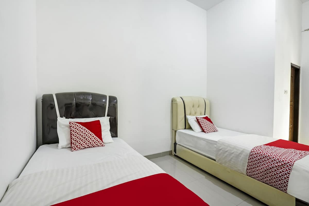 Une chambre d’hôtel avec deux lits, chacun doté d’une tête de lit et d’oreillers.