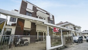 A modern two-story residential building with a gated entrance, a visible balcony, and a parked scooter. - OYO 90595 Ferezsa Kost Syariah (Palembang)