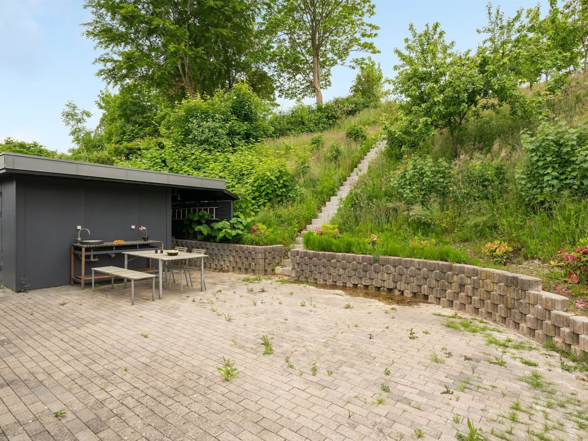 Un espace patio aménagé avec un barbecue intégré et des sièges.