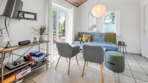 A modern living room with a blue sofa, grey chairs, a wooden ceiling, and a TV mounted on the wall. - "Anniesette" - 1.5km from the sea by Interhome (Blåvand)