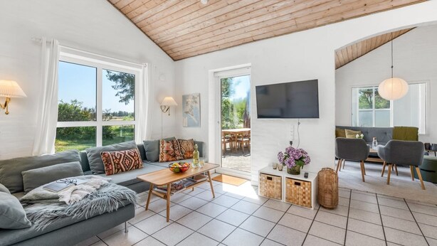 A modern living room with a grey sofa, wooden coffee table, and a TV mounted on the wall. - "Anniesette" - 1.5km from the sea by Interhome (Blåvand)
