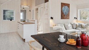 Ein modernes Interieur mit Küche, Essbereich und Wohnbereich.