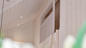 Ein Holzinnenraum mit Treppe und Geländer.