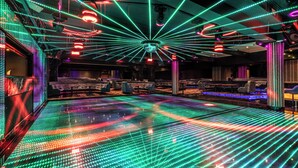 Une pièce dotée d’un sol équipé d’un écran LED dynamique, d’un éclairage d’ambiance et d’un aménagement intérieur moderne.