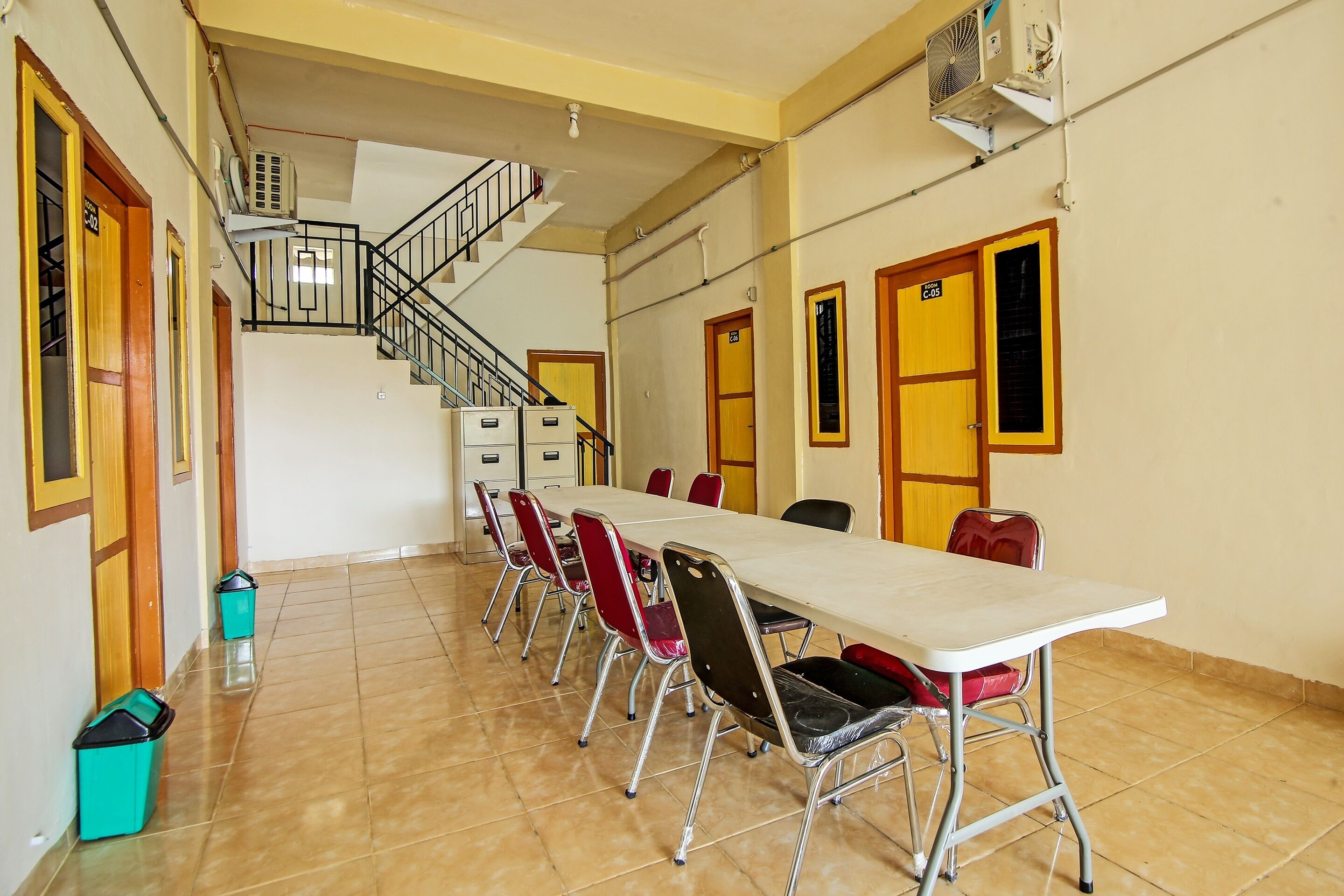A conference room with a long table, chairs, a staircase, and doors.