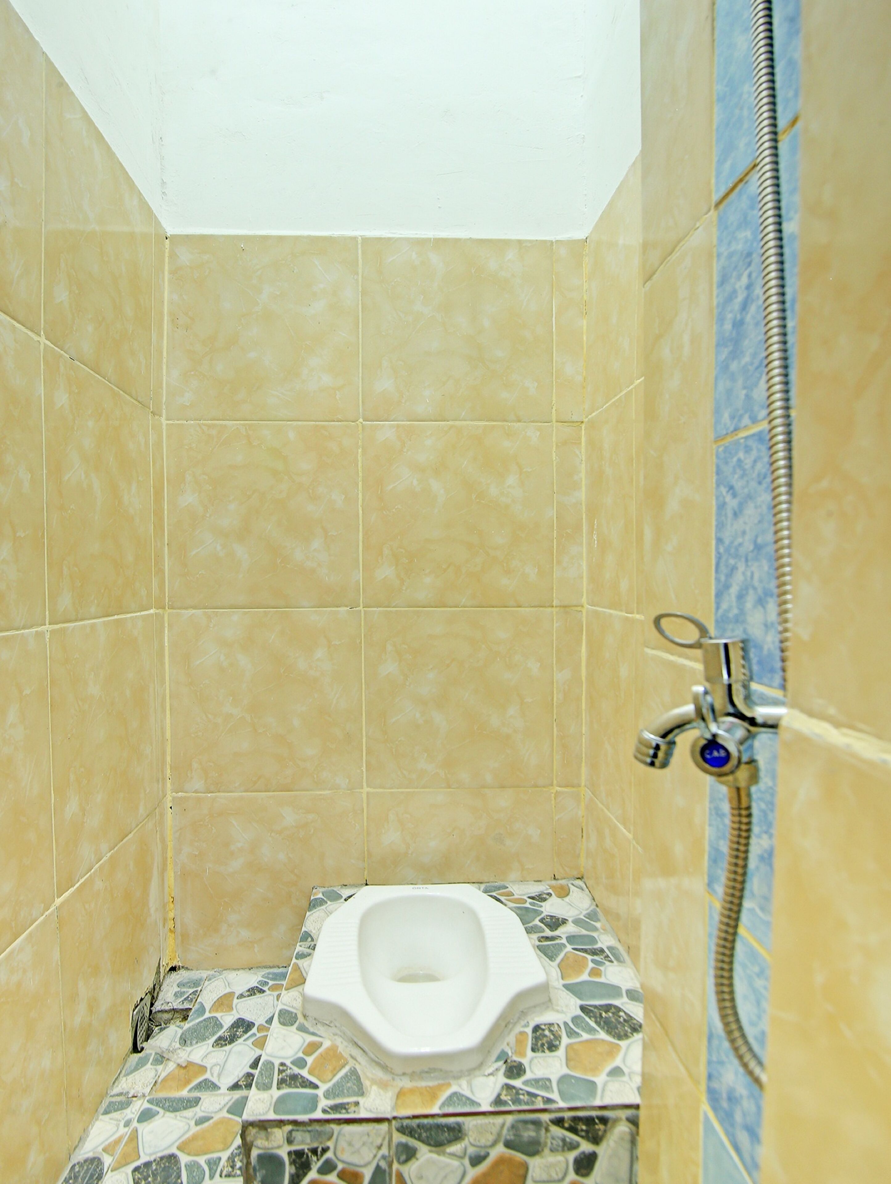 Un baño pequeño con inodoro, ducha y paredes de azulejos.