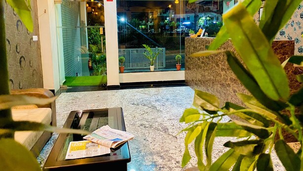 A lobby with a reception desk, a staircase, and potted plants. - Hotel Mock Orange (Jaipur)