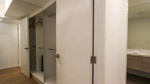 Ett modernt badrum med en stor spegel, ett vitt handfat och ett trägolv.