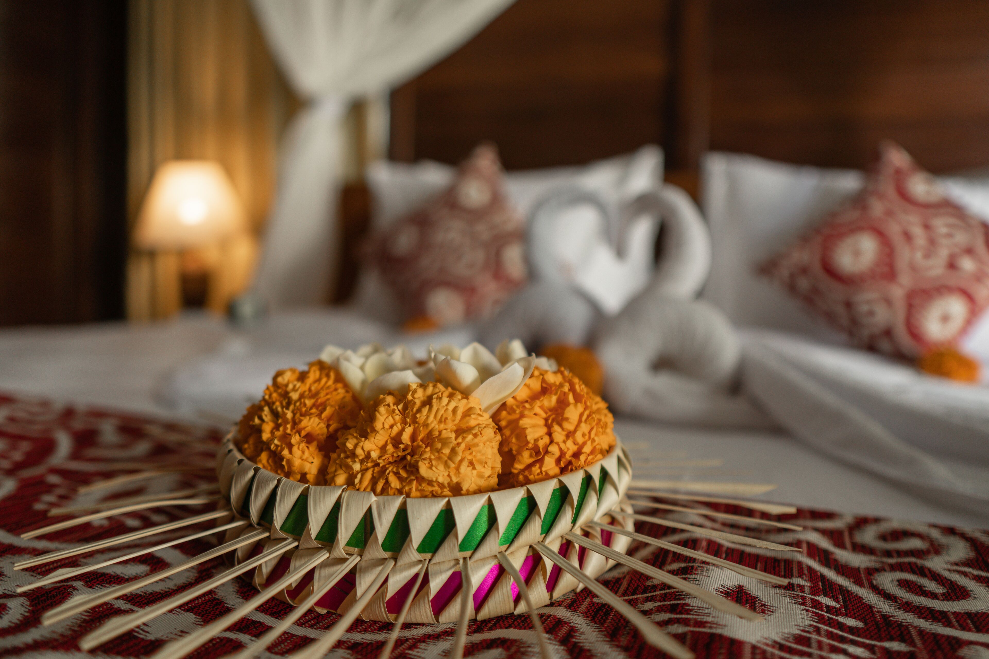A bed with a white canopy, a bedside table with a lamp, and decorative pillows.