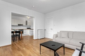 A modern apartment with a kitchen, dining area, and living room.