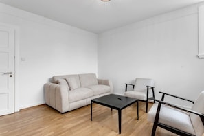 A minimalist living room with a sofa, two armchairs, and a coffee table.