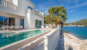 A modern villa with a swimming pool, outdoor seating, and a view of the sea. - More Brac in Selca With 4 Bedrooms and 4 Bathrooms (Selca)