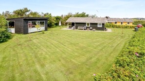 A residential property with a well-maintained lawn, a small patio area, and a house with a tiled roof. - "Bistra" - 400m from the sea by Interhome (Løkken)