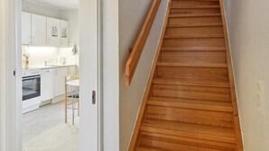 A wooden staircase with a handrail leading to a landing.