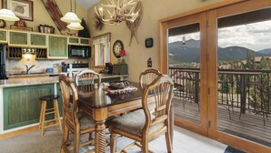 Cucina con zona pranzo, un lampadario e vista sulle montagne.