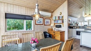 Ein gemütliches Blockhaus-Interieur mit Essbereich, Küche und Holzwänden.