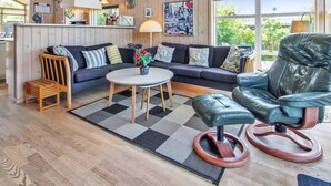Ein gemütliches Wohnzimmer mit einer Couch, einem Couchtisch und einem Ledersessel.