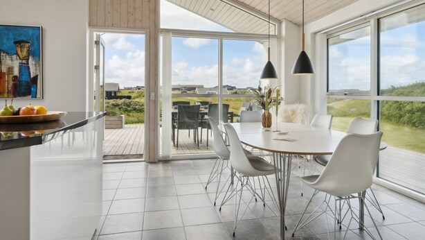 A modern kitchen with a large dining area, large windows, and a view of the countryside. - "Ohto" - 281m from the sea by Interhome (Hjørring)