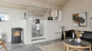 A modern living room with a fireplace, a sofa, a coffee table, and artwork on the walls. - "Ohto" - 281m from the sea by Interhome (Hjørring)