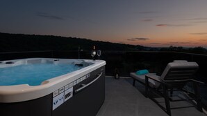 A hot tub with a glass enclosure, a lounge chair, and a view of the sunset. - Kala in Razanac With 4 Bedrooms and 2 Bathrooms (Razanac)
