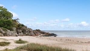 A beach with a rocky cliff and a clear sky. - "Tjelle" - 300m from the sea by Interhome (Allinge)