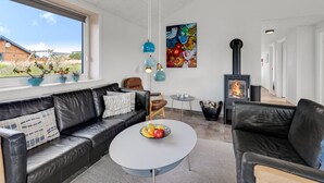 Ein modernes Wohnzimmer mit Sofa, Couchtisch und Kamin.
