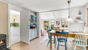 A spacious kitchen with a dining area, a fireplace, and a view of the outdoors. - "Carly" - 100m from the sea by Interhome (Væggerløse)