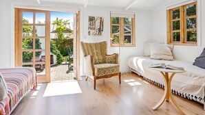 A bright room with a large window, a sofa, a chair, and a table. - "Carly" - 100m from the sea by Interhome (Væggerløse)