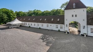 En byggnad med en vit fasad, en central portal och ett klocktorn.