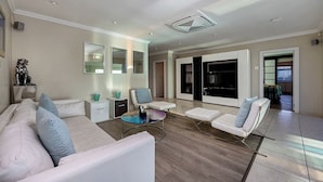A modern living room with a sofa, two armchairs, a coffee table, and a fireplace. - Sir David Baird 22 (Cape Town)