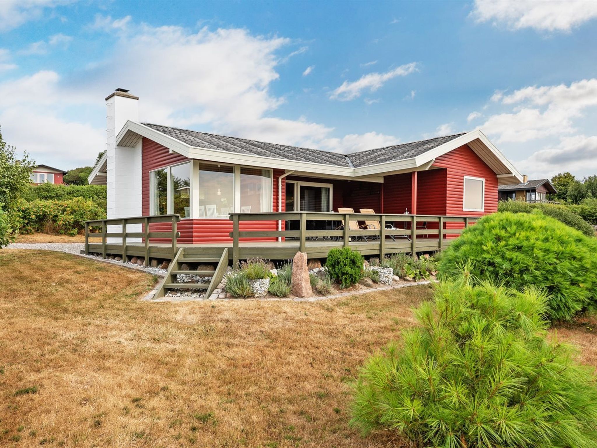 A red and white house with a covered porch and a small deck.