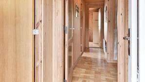Un pasillo de madera con ventilador de techo, puertas de madera y suelo de madera.