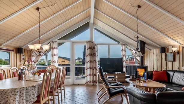 Une salle à manger spacieuse avec un haut plafond, un téléviseur et une cheminée.