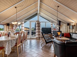A spacious dining area with a high ceiling, a television, and a fireplace. - "Freya" - 200m from the sea by Interhome (Løkken)