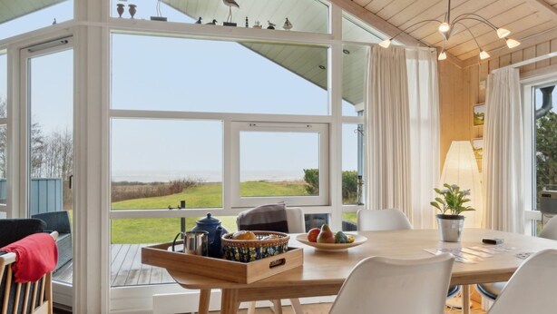 A modern dining area with a large window offering a view of the outdoors. - "Hane" - 150m from the sea by Interhome (Hadsund)