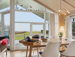 Een moderne eetruimte met een groot raam dat uitzicht biedt op het omliggende landschap.