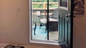 A sliding glass door leading to a deck with outdoor furniture. - Pet-Friendly Space, King bed, Office (Halifax)