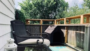 A balcony with a wicker chair, a small dog house, and a lantern. - Pet-Friendly Space, King bed, Office (Halifax)