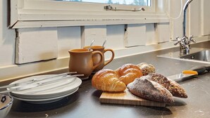 Een aanrecht met croissants, een koffiemok en een snijplank.