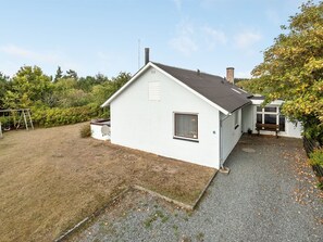 Ett litet vitt hus med ett sluttande tak, en skorsten och ett litet fönster.