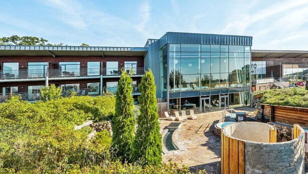 A modern building with a glass facade, outdoor seating, and a stone pathway. - "Joris" - 100m to the fjord by Interhome (Gråsten)