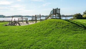 A playground with a slide and climbing structures near a lake. - "Joris" - 100m to the fjord by Interhome (Gråsten)