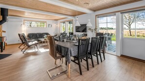 A spacious dining area with a wooden ceiling, large windows, and a view of the outdoors. - "Adelia" - 850m to the fjord by Interhome (Tarm)
