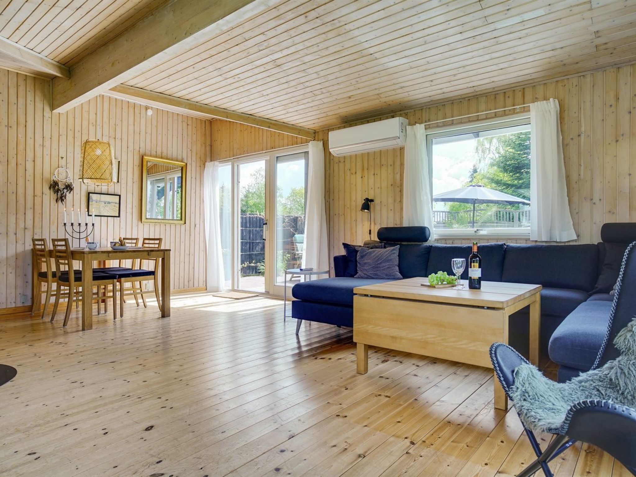 Et træinteriør med et spiseområde, en sofa og et sofabord.