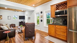A modern kitchen with wooden cabinets, a stainless steel refrigerator, and a built-in microwave. - 16 mi to DT, Hot Tub, Fire Pit, FP, Basket Ball Court, Mt View, Secluded & Quiet (Barnardsville)
